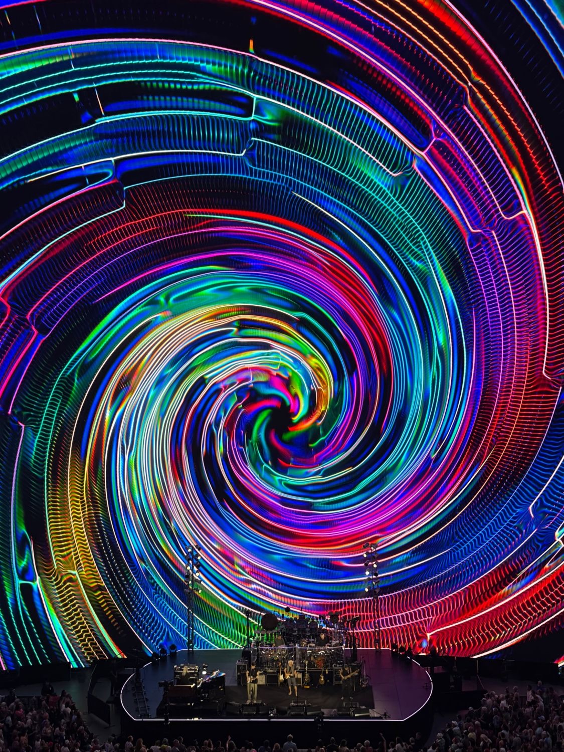 A huge spiral of coloured light over a concert stage